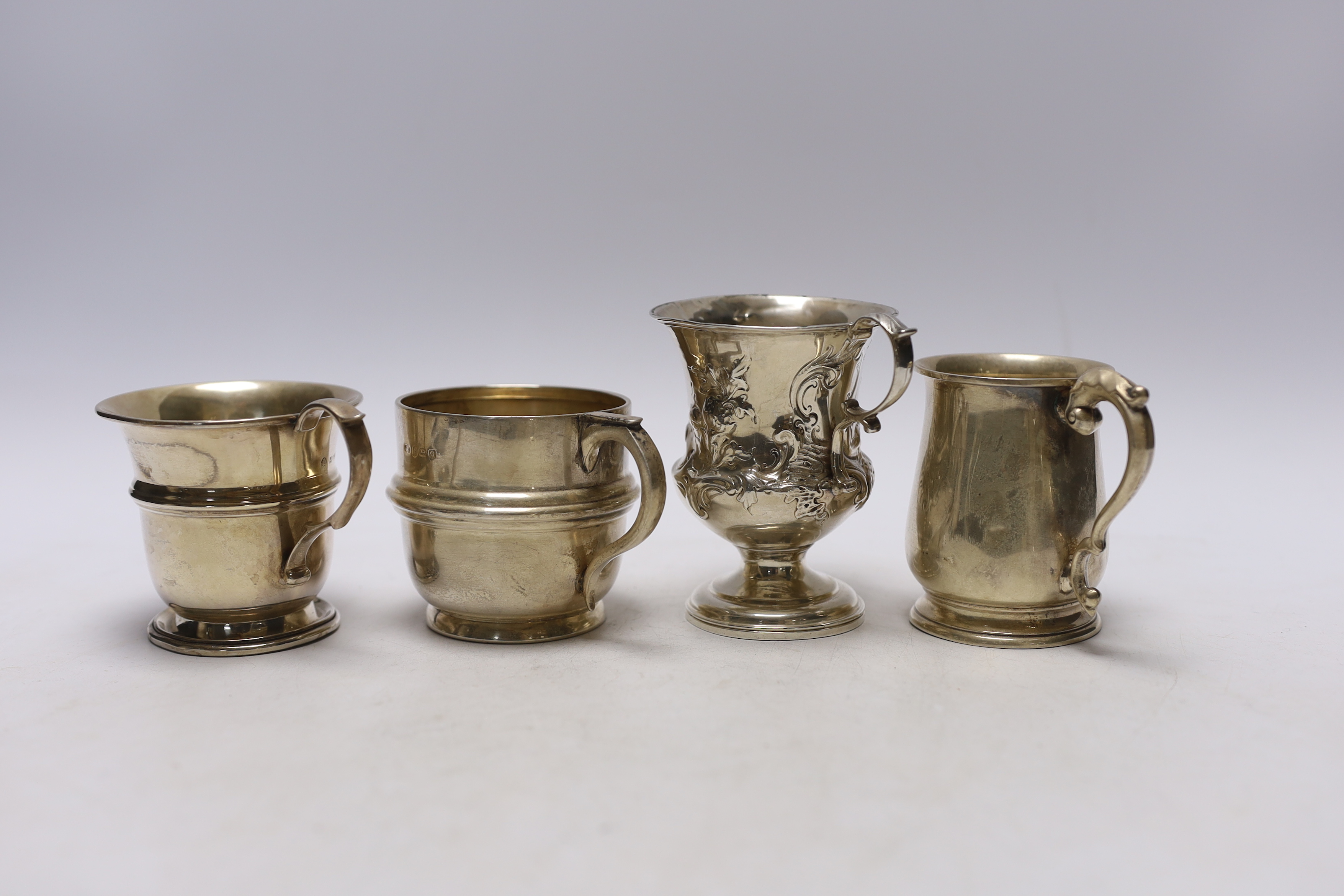 An early Victorian repousse silver pedestal christening mug, Charles Fox, London, 1839, 95mm and three later silver christening mugs, 10.7oz.